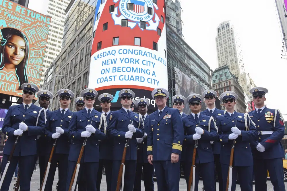 Coast Guard standing in front of Nasdaq Ad 